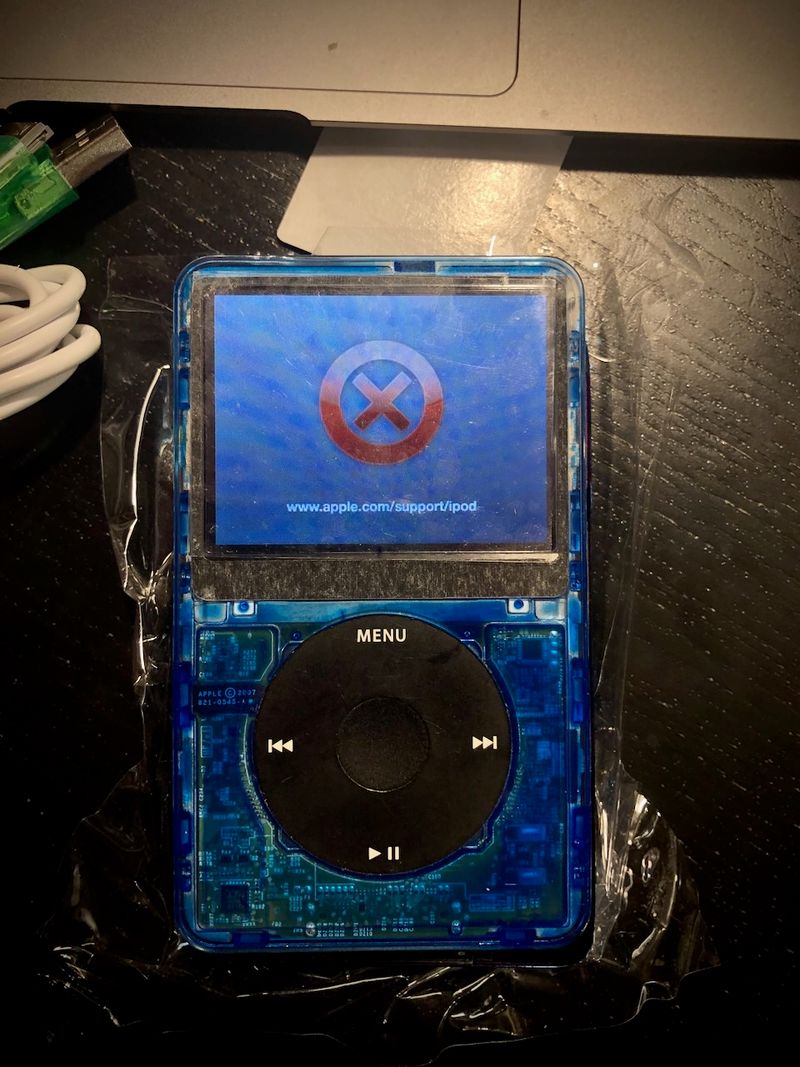 A custom iPod Classic in a blue translucent case with an error sign and a link to www.apple.com/support/ipod on its screen